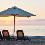 A serene sunset on the beach, highlighting the beauty of nature while reminding to protect furniture from sun damage.