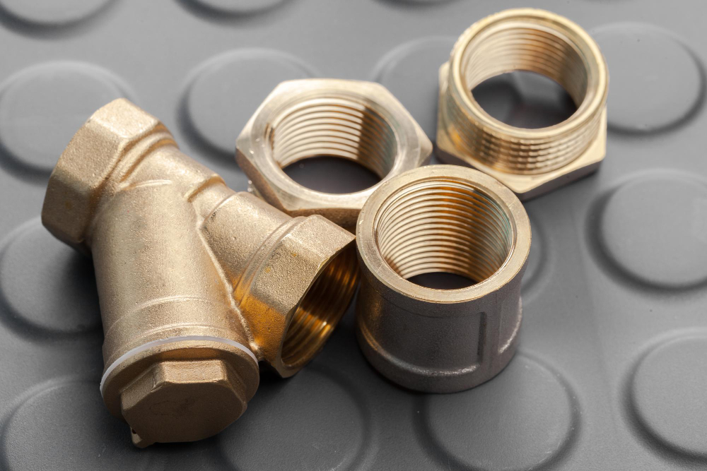 Metallic hex coupler fittings in brass on black